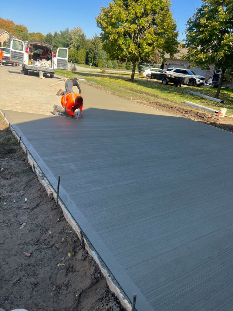 Men finishing edging on a driveway extension