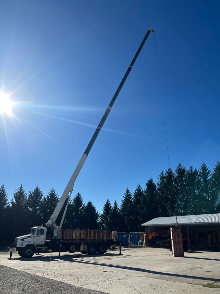Crane truck unloading concrete forms